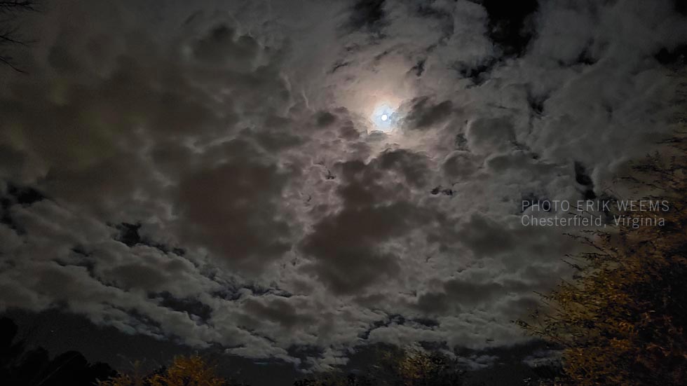 Moon among dark clouds photo Erik Weems