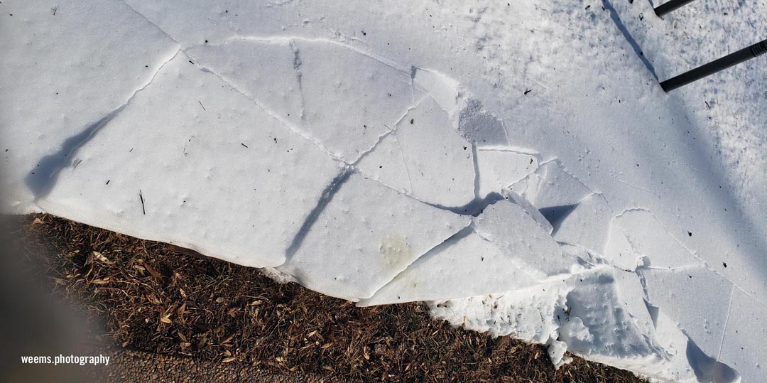 Snow cracks and grass in Chantilly